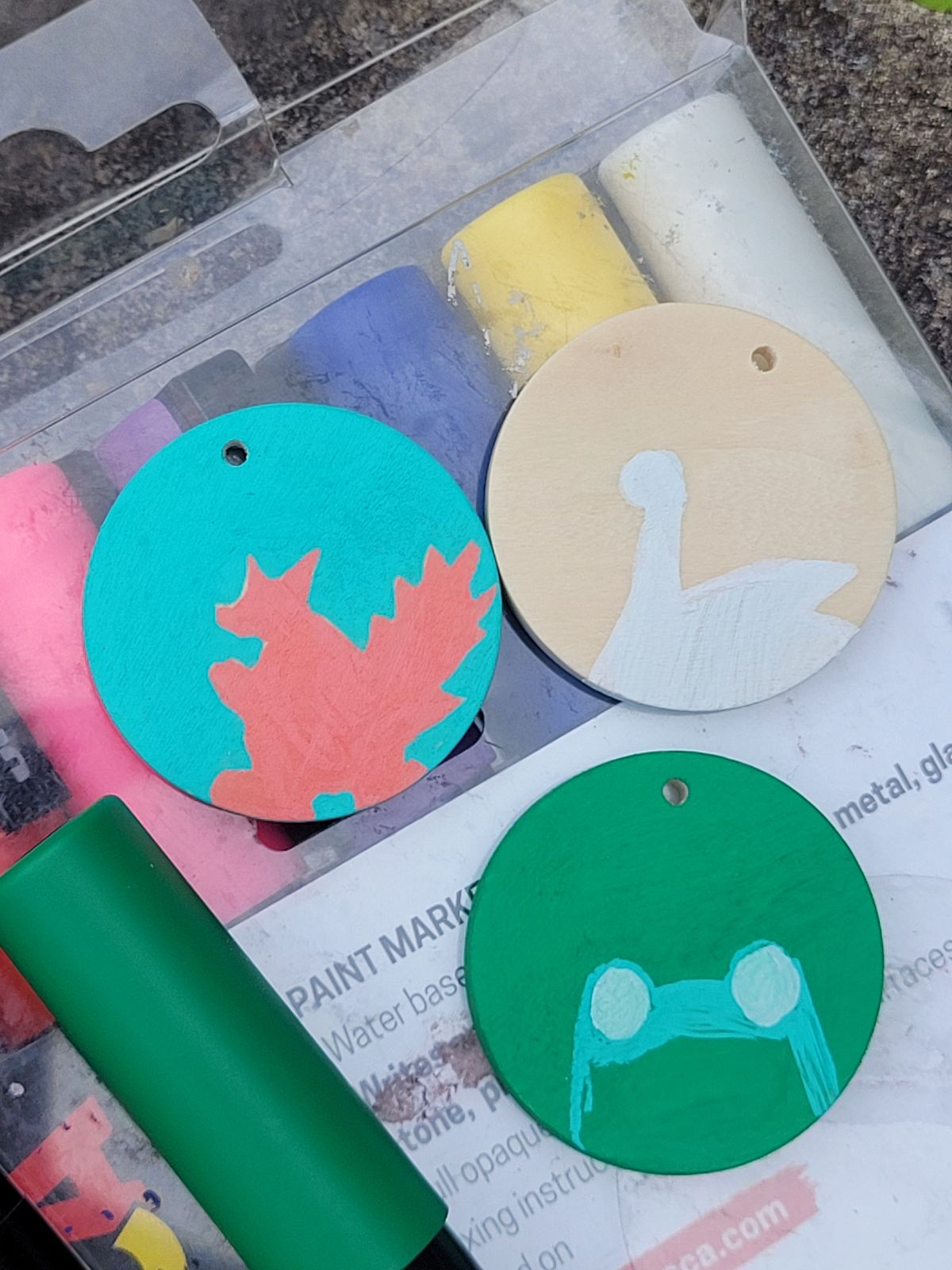 Close in photo of in progress badges outdoors. You can see the shapes being drawn are a squirrel, frog and goose.