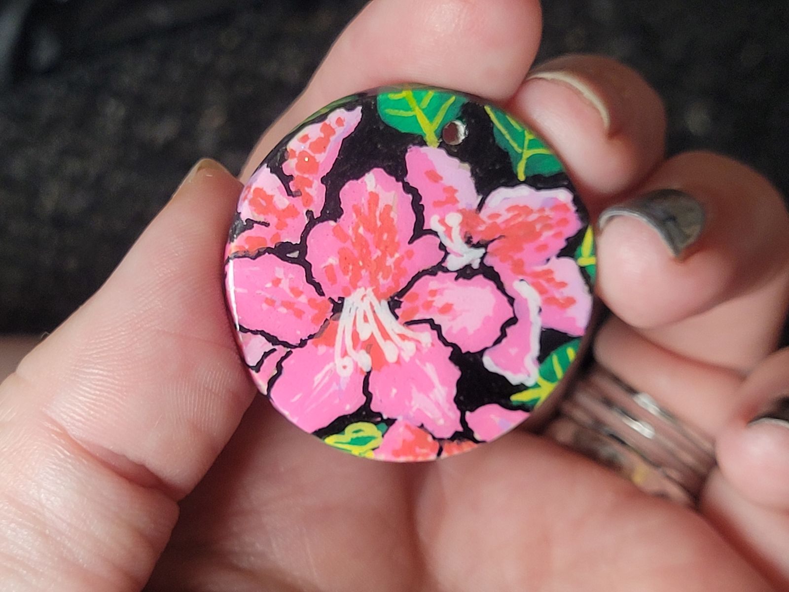 Badge featuring a bright pink and red rhododendron flower.