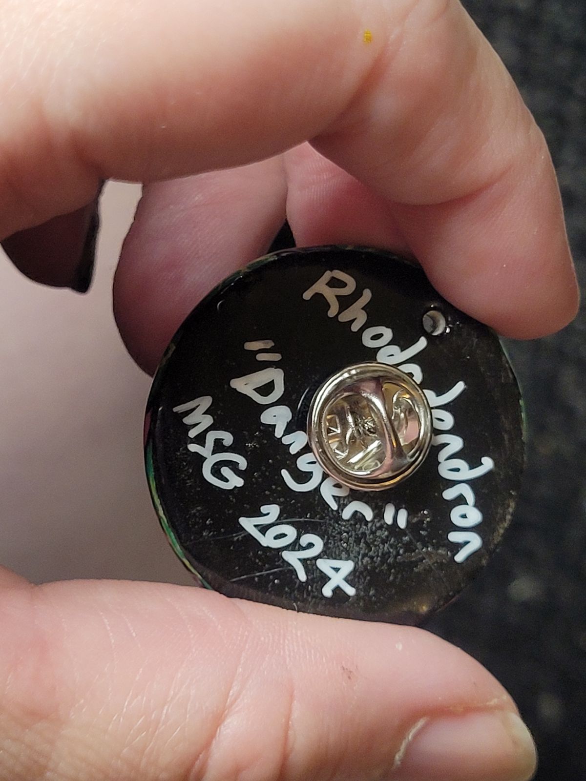 Reverse of the rhododendron badge reads 'Rhododendron - Danger' and the artist's signature.