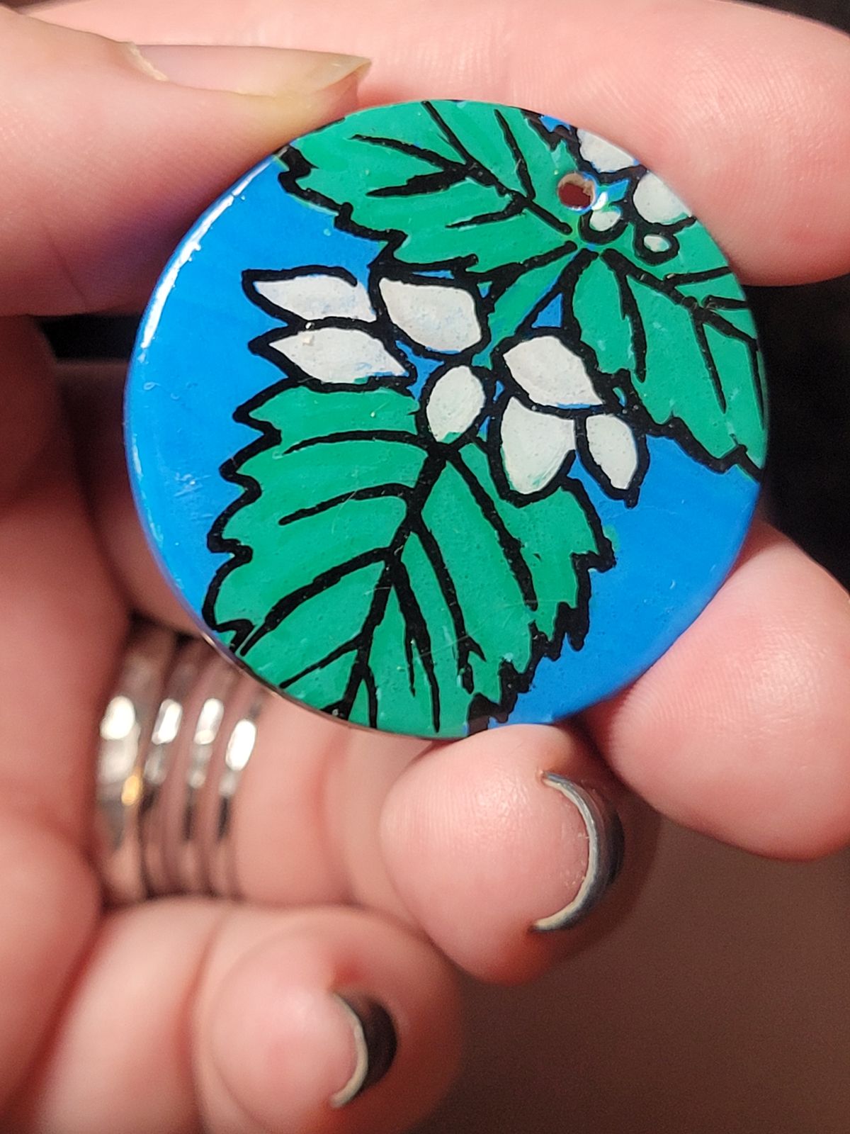 Badge featuring white nettle flowers, and nettle leaves.