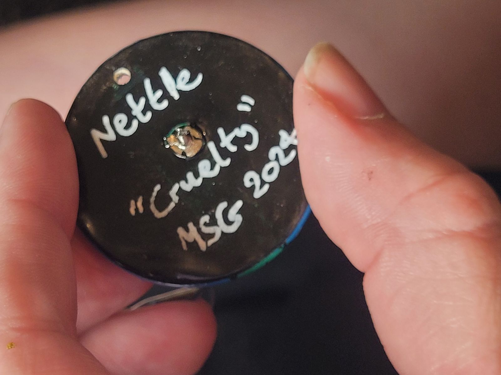 Reverse of nettle badge reads 'Nettle - Cruelty', and the artist's signature.