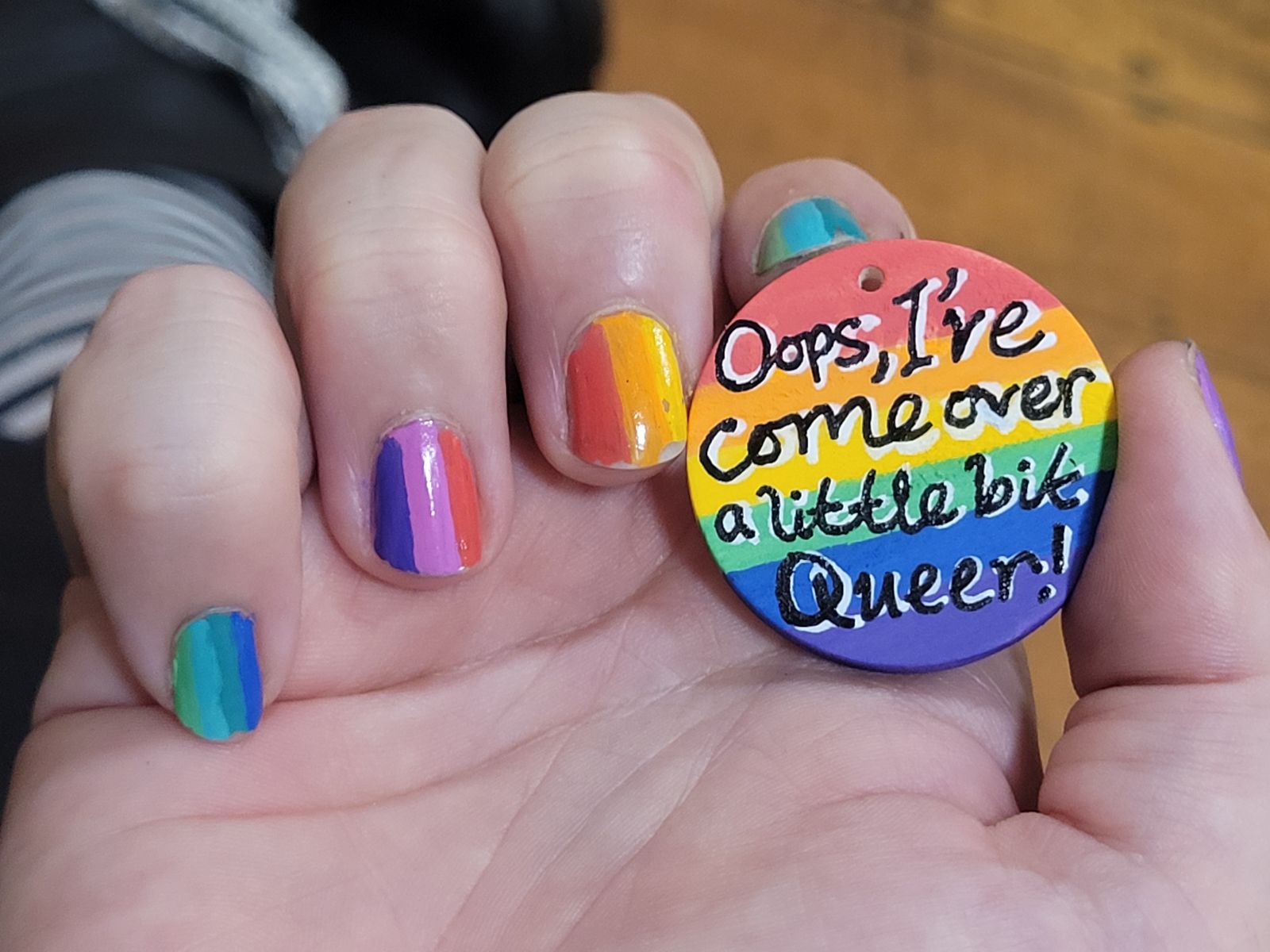 Rainbow badge reads 'Oops, I've come over a little bit queer!'